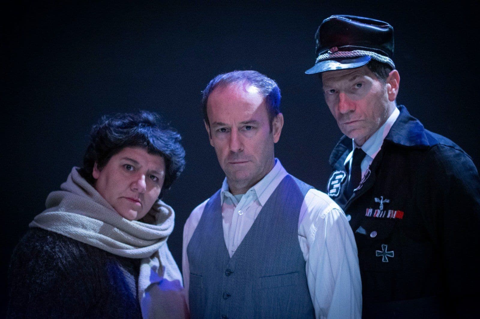 Tres intérpretes de Dr. Korczak, última decisión, uno con gorra de uniforme