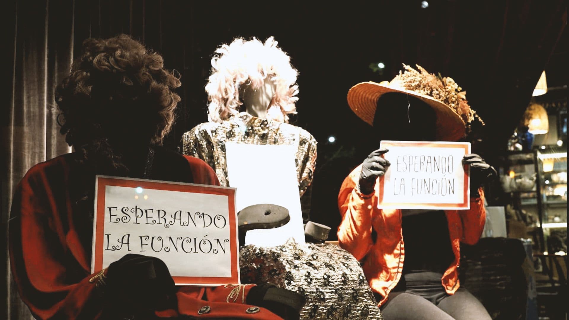 Maniquíes con carteles que dicen «Esperando la función»