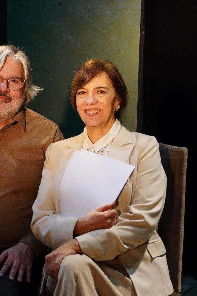 Una actriz con un texto en la mano, sentada junto al pianista