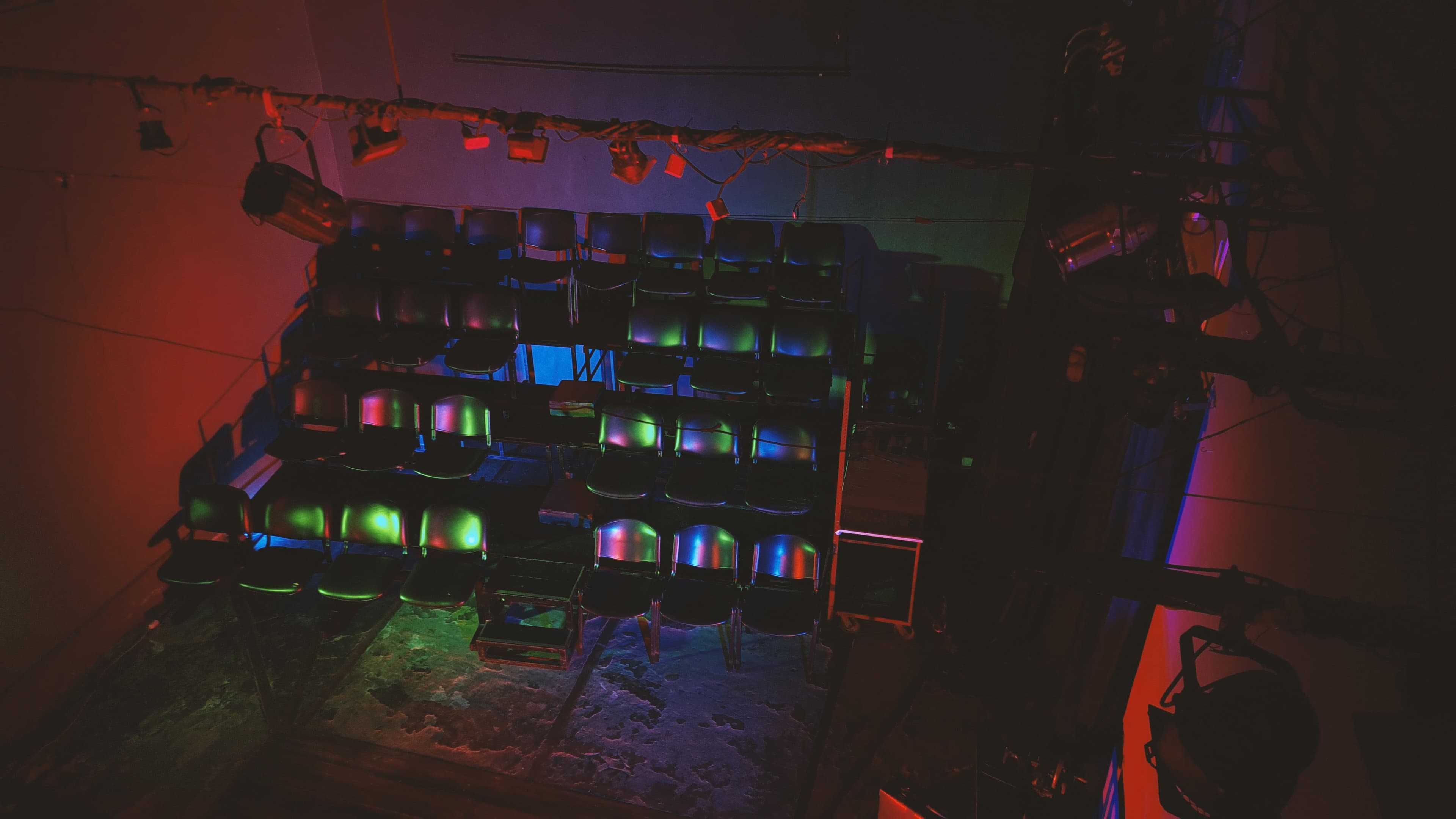 La sala con las gradas iluminadas con luces de colores